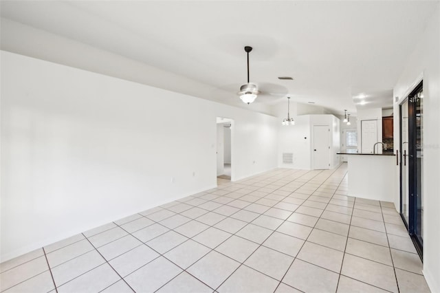 spare room with light tile patterned floors, visible vents, lofted ceiling, and a ceiling fan