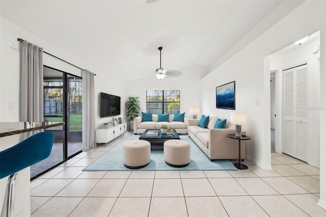 living room featuring light tile patterned floors, plenty of natural light, and vaulted ceiling