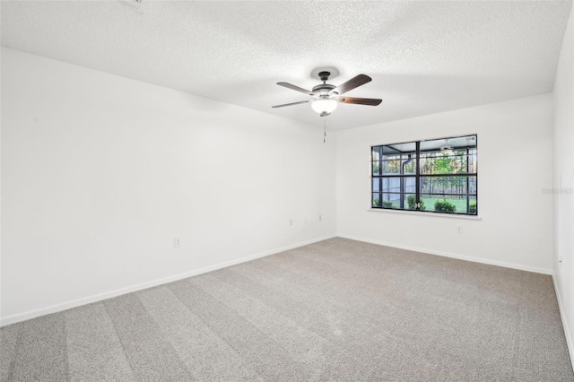 unfurnished room featuring a textured ceiling, carpet flooring, baseboards, and ceiling fan