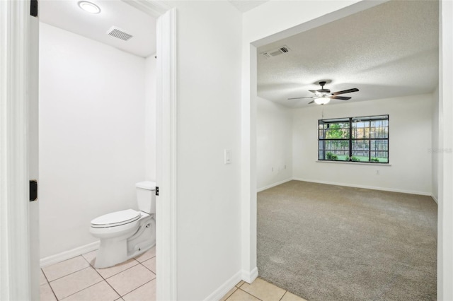 bathroom with tile patterned flooring, toilet, visible vents, and ceiling fan