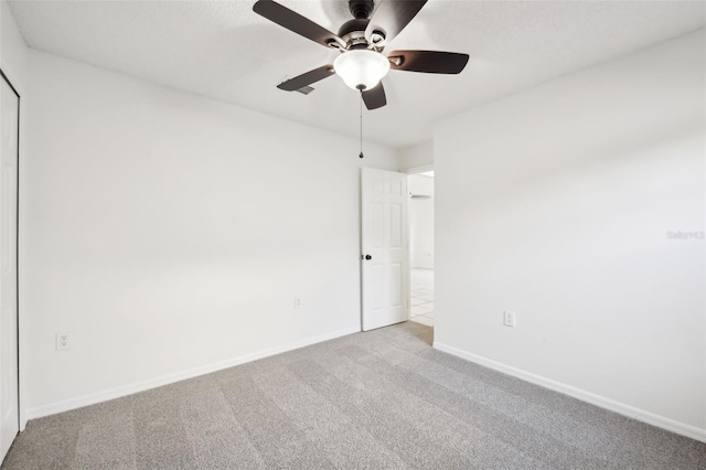 spare room featuring baseboards, carpet floors, and a ceiling fan