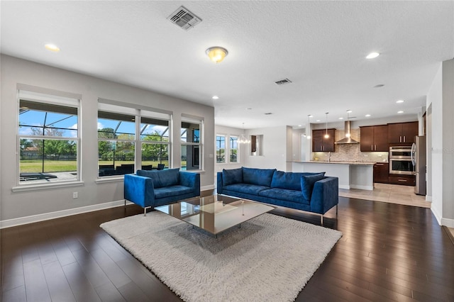 living room with dark wood-type flooring, baseboards, and visible vents