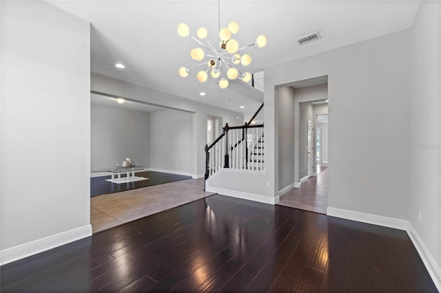 interior space featuring a notable chandelier, stairway, baseboards, and wood finished floors