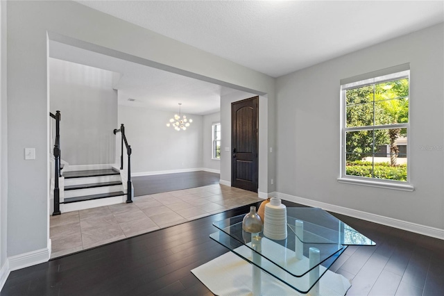 foyer entrance featuring stairway, baseboards, and wood finished floors