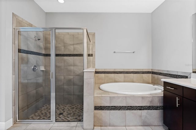 bathroom with vanity, a shower stall, a garden tub, and tile patterned flooring