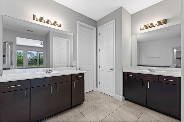 full bathroom featuring tile patterned flooring, two vanities, visible vents, and a sink