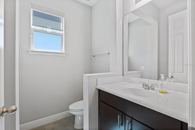 bathroom featuring baseboards, toilet, vanity, and tile patterned flooring