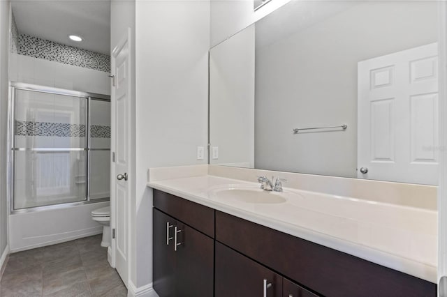 full bathroom featuring tile patterned flooring, toilet, vanity, and bath / shower combo with glass door