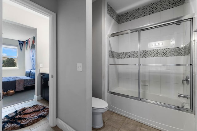 ensuite bathroom featuring baseboards, toilet, tile patterned floors, combined bath / shower with glass door, and ensuite bath