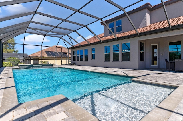 view of swimming pool with a patio area, a pool with connected hot tub, and a lanai