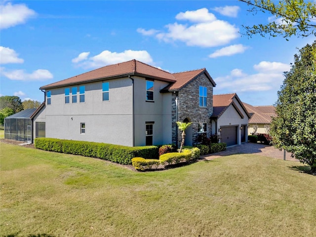 view of side of home featuring stucco siding, a lawn, driveway, a tile roof, and a garage