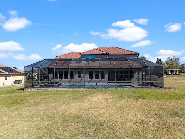 back of property featuring glass enclosure, a tiled roof, and a yard