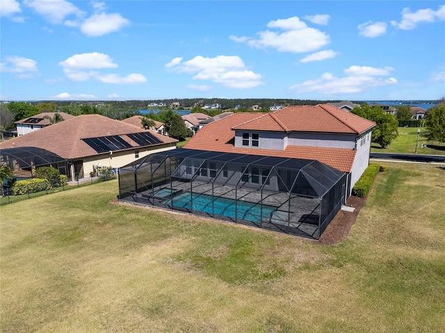 pool with glass enclosure, a patio area, and a lawn