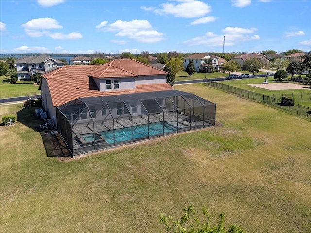 view of swimming pool featuring a lanai, a fenced in pool, a lawn, and fence