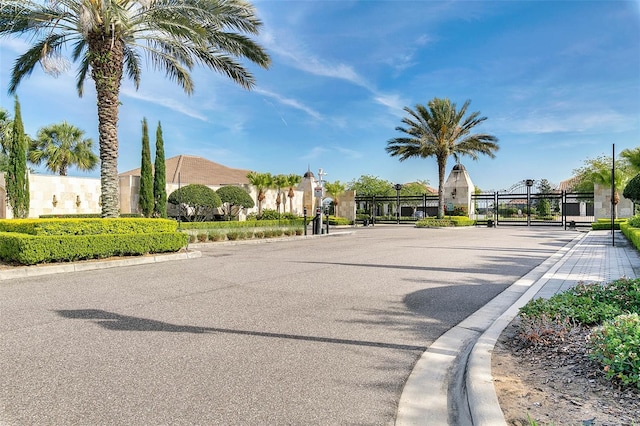 view of street with curbs, a gated entry, and a gate