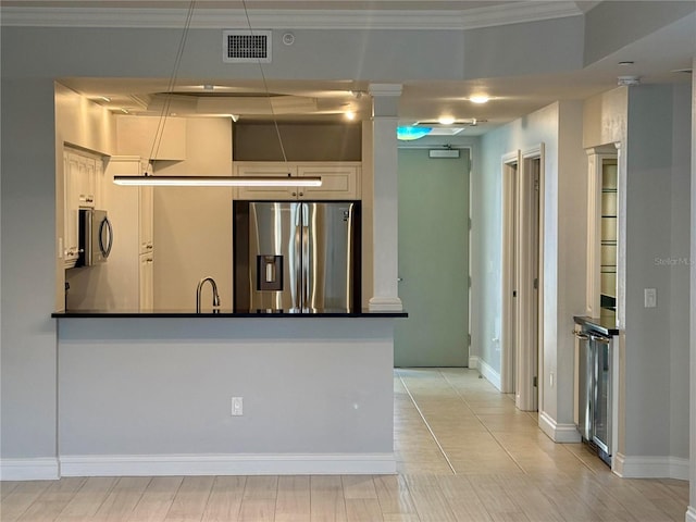 kitchen featuring visible vents, a peninsula, ornamental molding, appliances with stainless steel finishes, and dark countertops