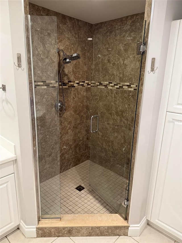 full bath featuring a shower stall, baseboards, and tile patterned floors