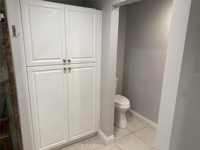 bathroom featuring baseboards, toilet, and tile patterned flooring