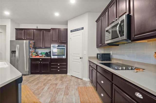 kitchen featuring dark brown cabinetry, black appliances, light countertops, and tasteful backsplash