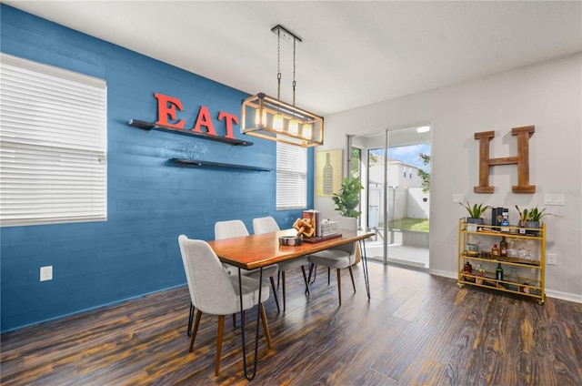 dining area with a chandelier, baseboards, and wood finished floors