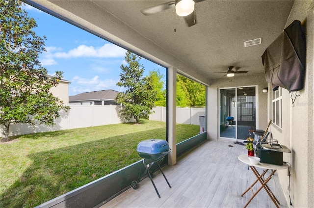 sunroom featuring visible vents and ceiling fan