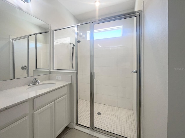 full bathroom with a stall shower, vanity, and tile patterned flooring