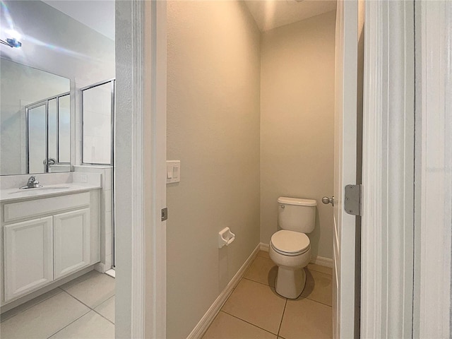 bathroom with tile patterned floors, toilet, vanity, and baseboards