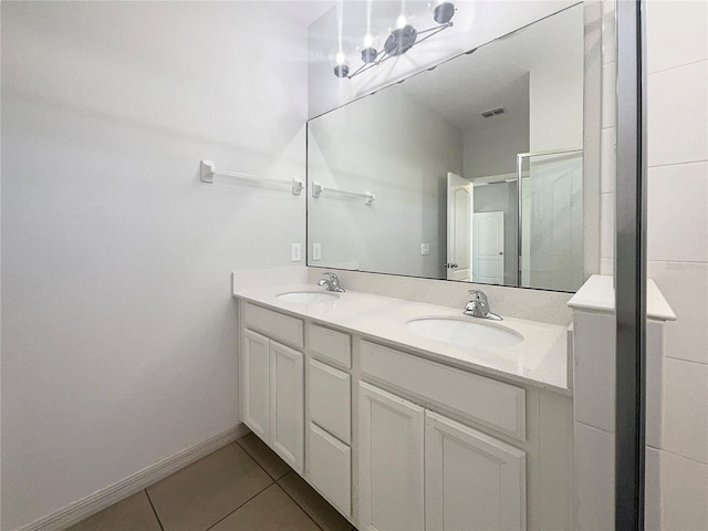 bathroom with a sink, baseboards, double vanity, and tile patterned floors