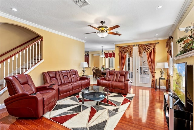 living room with visible vents, ornamental molding, french doors, and wood finished floors