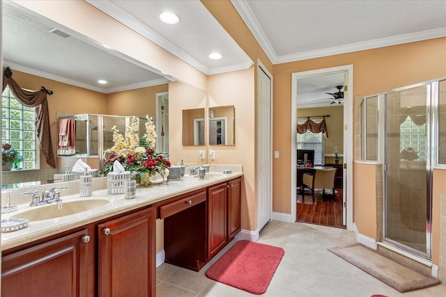 bathroom featuring tile patterned floors, ornamental molding, a stall shower, and a sink