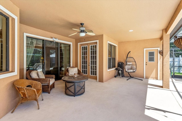 view of patio / terrace featuring glass enclosure and a ceiling fan