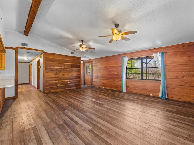 16510 Quarter Horse Ct, Montverde, FL 34756 - unfurnished living room featuring visible vents, vaulted ceiling with beams, ceiling fan, wood finished floors, and a textured ceiling