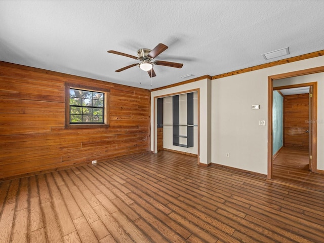 16510 Quarter Horse Ct, Montverde, FL 34756 - empty room with wooden walls, baseboards, ceiling fan, wood finished floors, and a textured ceiling