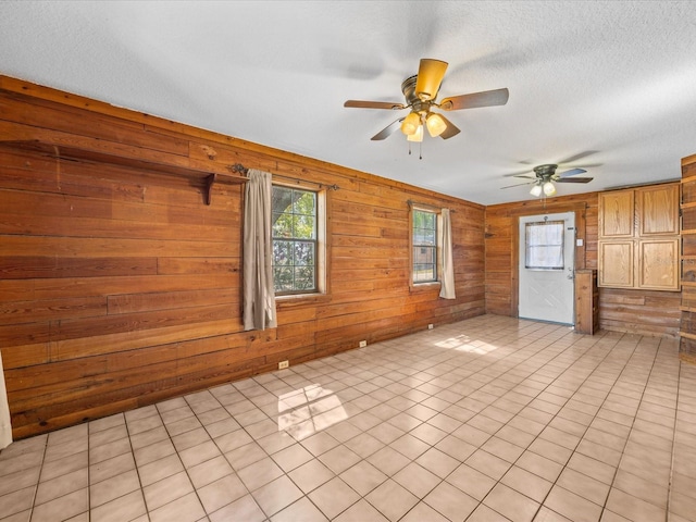 16510 Quarter Horse Ct, Montverde, FL 34756 - spare room featuring a textured ceiling, wooden walls, light tile patterned floors, and ceiling fan