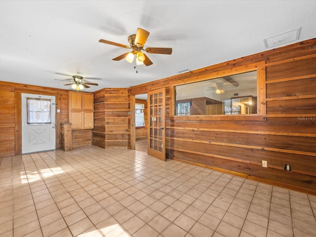 16510 Quarter Horse Ct, Montverde, FL 34756 - unfurnished living room featuring wooden walls, light tile patterned floors, french doors, and ceiling fan