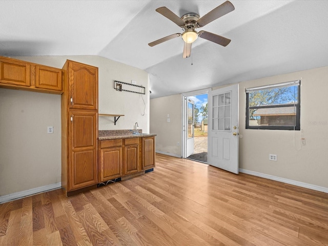 16510 Quarter Horse Ct, Montverde, FL 34756 - kitchen with light wood finished floors, brown cabinets, a wealth of natural light, and lofted ceiling