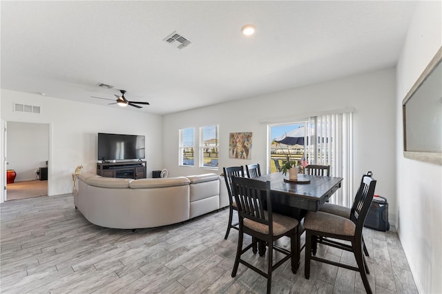 dining area featuring visible vents, light wood-style flooring, and a ceiling fan