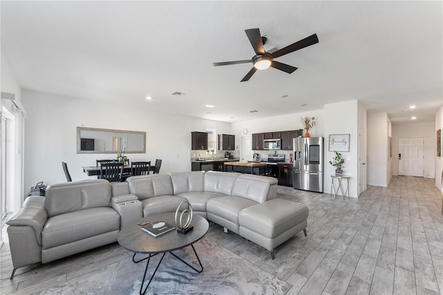 living area with recessed lighting, light wood-style floors, and ceiling fan