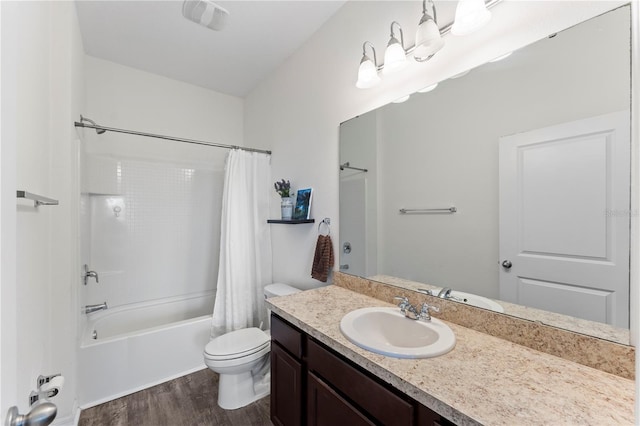 bathroom featuring vanity, wood finished floors, visible vents, shower / tub combo, and toilet