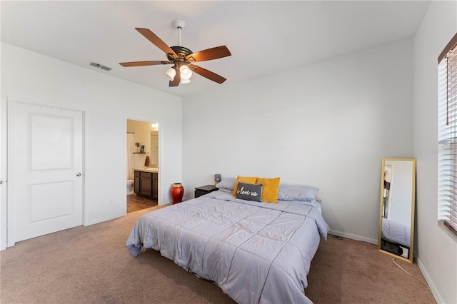 bedroom with visible vents, light carpet, a ceiling fan, connected bathroom, and baseboards