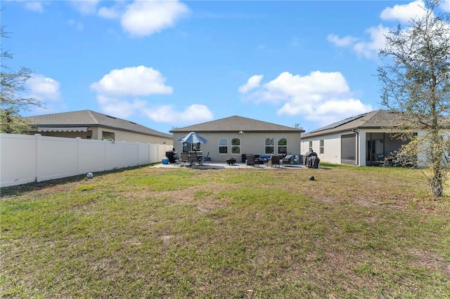 back of property featuring a yard, a patio area, a fenced backyard, and stucco siding