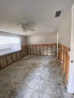 unfurnished room featuring visible vents, concrete flooring, and ceiling fan