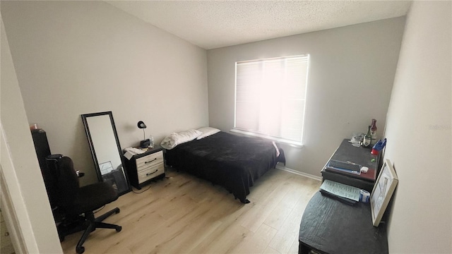 bedroom featuring light wood-style flooring and a textured ceiling