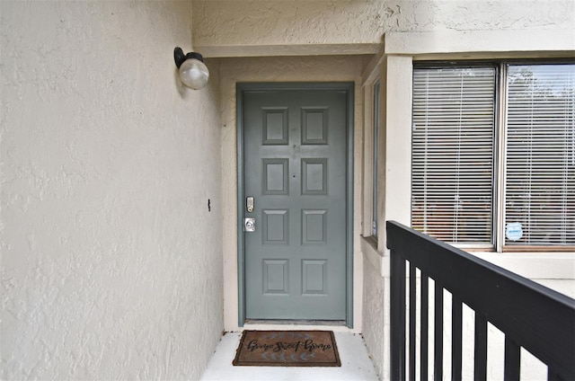 view of exterior entry with stucco siding