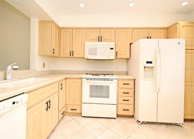 kitchen featuring light brown cabinetry, a sink, white appliances, light countertops, and light tile patterned floors