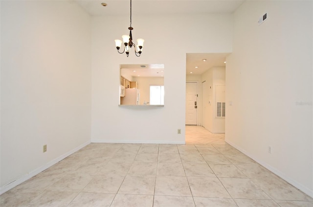 unfurnished room featuring light tile patterned floors, visible vents, baseboards, and a chandelier