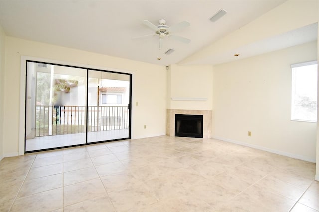 unfurnished living room featuring baseboards, vaulted ceiling, a tile fireplace, light tile patterned flooring, and a ceiling fan