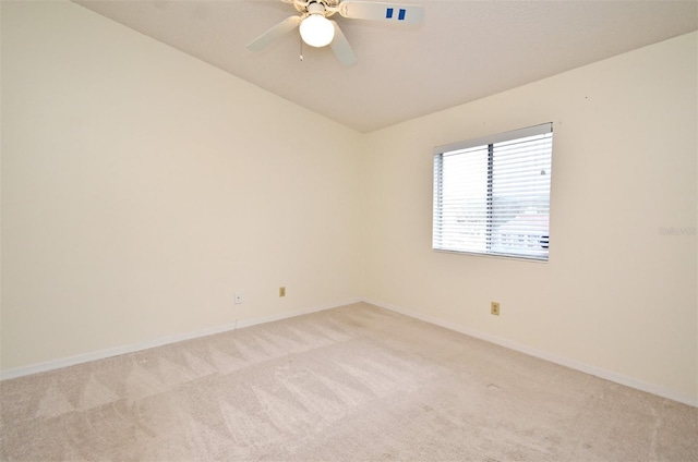 unfurnished room featuring light carpet, baseboards, a ceiling fan, and vaulted ceiling