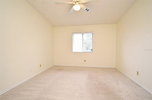 spare room featuring baseboards, light colored carpet, and ceiling fan