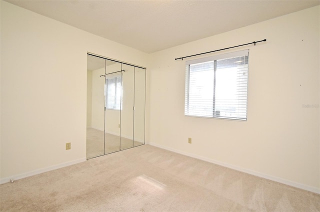 unfurnished bedroom with a closet, baseboards, and carpet